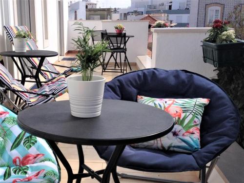 a table with a chair and a plant on a balcony at Bedrooms AP Garden in Lagos