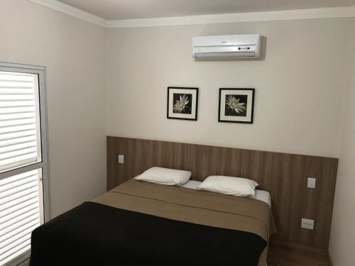 um quarto com uma cama e ar condicionado em Hotel Villaggio Nobre em Limeira