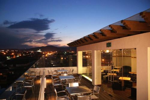 a balcony with tables and chairs on a building at Hotel 9 Manantiales in Chignahuapan