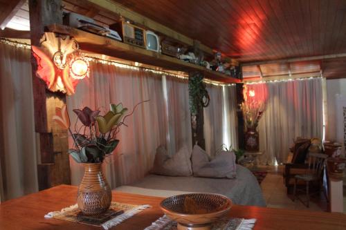Loft São Joaquim في ساو جواكيم: غرفة نوم بسرير وطاولة مع ورد