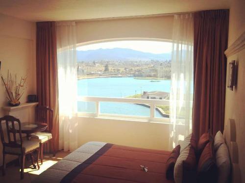 a bedroom with a window with a view of the water at Hotel 9 Manantiales in Chignahuapan