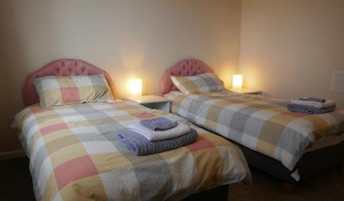 dos camas sentadas una al lado de la otra en una habitación en Inverness Family House, en Inverness