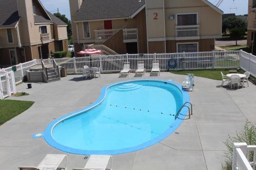 a large blue swimming pool in front of a house at Hawthorn Suites Wichita East in Wichita