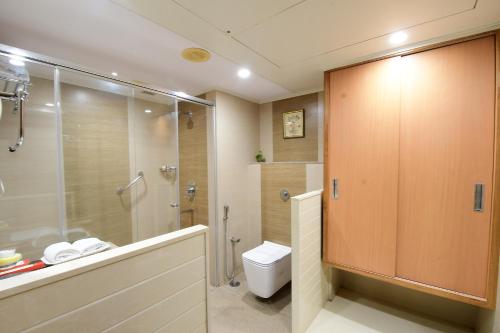 a bathroom with a shower and a toilet and a sink at Hotel Daspalla in Visakhapatnam