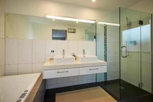 La salle de bains est pourvue de 2 lavabos et d'une douche. dans l'établissement The Fairways Luxury Accommodation Kaikoura, à Kaikoura