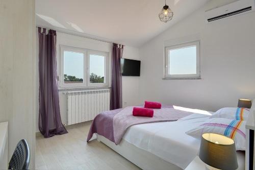 Un dormitorio con una cama con almohadas rojas. en Villa Zeus, en Pula