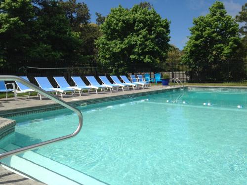 a swimming pool with chaise lounges and chairs at Chatham Seafarer Inn in Chatham