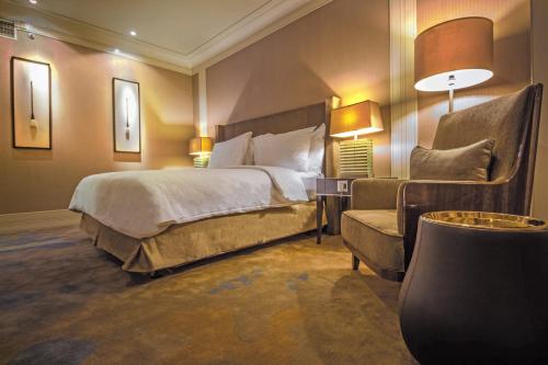 a bedroom with a bed and a couch and a chair at I Hotel Batam in Nagoya
