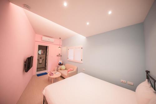 a small bedroom with a bed and a chair at Urban in Kaohsiung