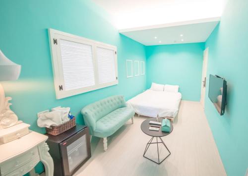 a blue room with a bed and a couch at Urban in Kaohsiung