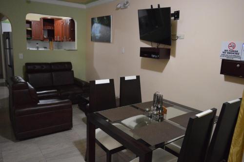 a living room with a dining table and a television at The Clover 20-28 in Palmira