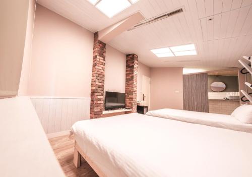 a bedroom with two beds and a television in it at Urban in Kaohsiung