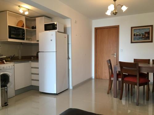 uma cozinha com um frigorífico branco e uma mesa em Palm Beach em Montevidéu