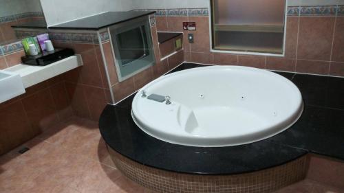 a bathroom with a white sink and a mirror at Treasure Island Motel - Fengshan in Kaohsiung