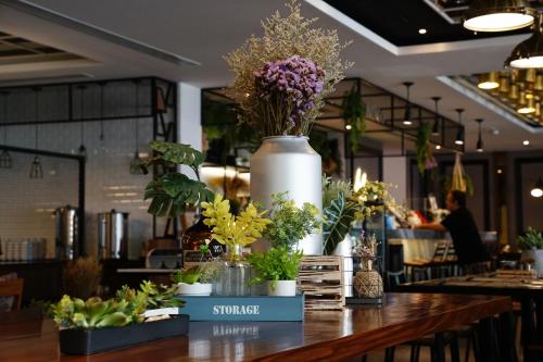 a table with potted plants on top of it at 130 Hotel & Residence Bangkok in Bangkok