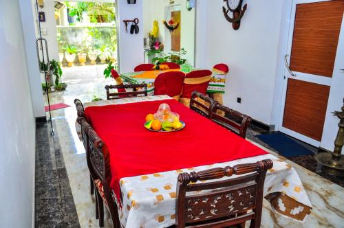 een rode tafel met een fruitschaal erop bij Rock Cascade tourist home in Polonnaruwa