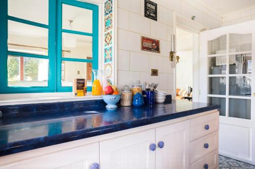 una cocina con armarios blancos y una ventana azul en Abriga Bed and Breakfast, en Coyhaique