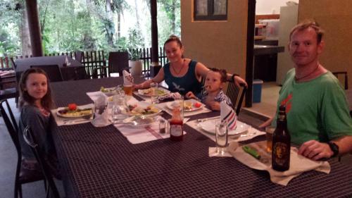 a man and woman sitting at a table with a child at Nature's Hideout Holiday Home in Mirigama