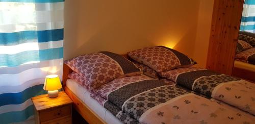 two beds in a room with a lamp and a window at Haus Schneider in Winterberg