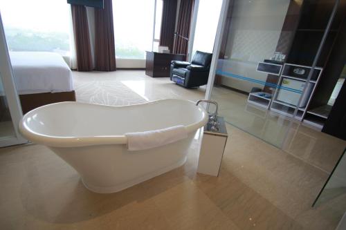 a bathroom with a bath tub in a hotel room at Grand Tebu Hotel in Bandung