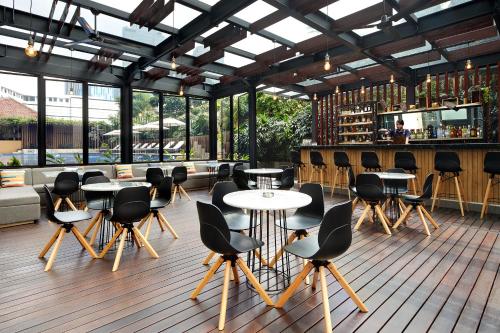 a restaurant with tables and chairs and a bar at Fraser Residence Menteng Jakarta in Jakarta