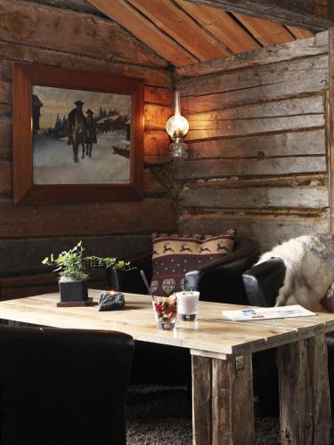 a wooden table in a room with a couch and a table sidx sidx at Buustamons Fjällgård in Åre