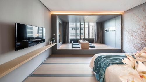 a bedroom with a television and a living room at Shanghai Pagoda INNO Hotel in Shanghai