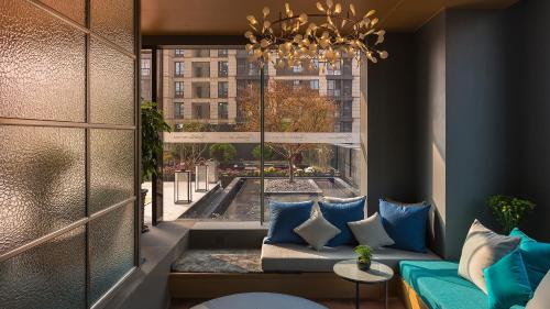 a living room with a couch and a large window at Shanghai Pagoda INNO Hotel in Shanghai