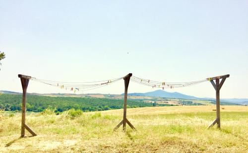 a couple of wooden poles in a field at Locanda Vesuna Hotel Countryhouse in Pienza