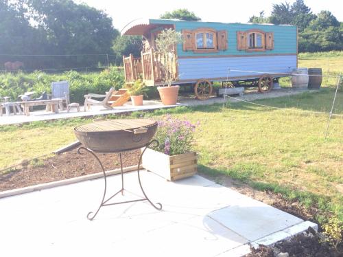 a grill in front of a tiny house at Roulotte de luxe vue mer 180° ,et un ha de verdure in Plougastel-Daoulas
