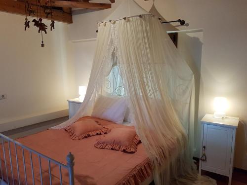 łóżko z moskitierą w sypialni w obiekcie Onirozo Koroni Private Villa w Koroni