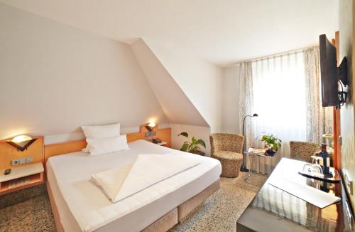 sypialnia z dużym białym łóżkiem i oknem w obiekcie Top Hotel Krämer w Koblencji