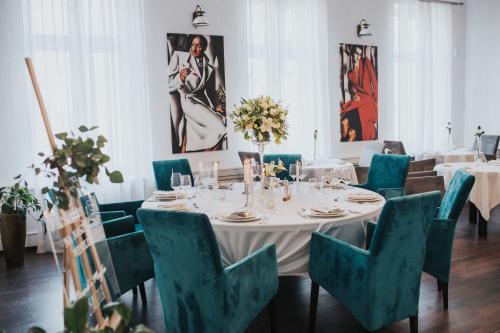a dining room with a white table and blue chairs at Matejki 8 in Szczecin