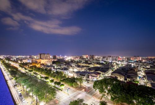 a city lit up at night with buildings and trees at Royal Chiayi Hotel in Chiayi City