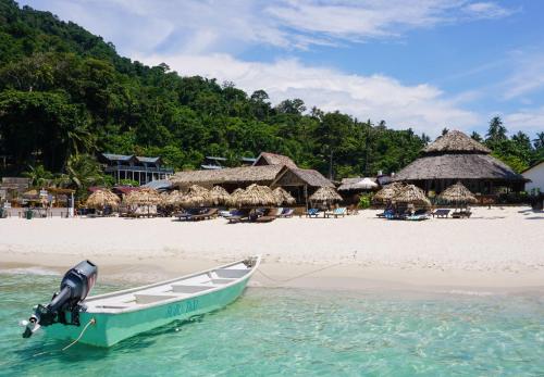 a boat in the water on a beach at BuBu Villa in Perhentian Island