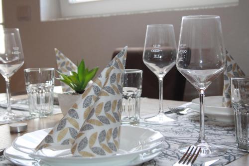 a table with wine glasses and a plate with a napkin at Apartmani Prisoje in Žabljak