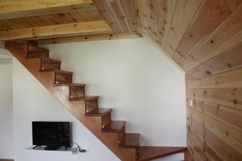 a room with a staircase with a flat screen tv at Apartmani Prisoje in Žabljak