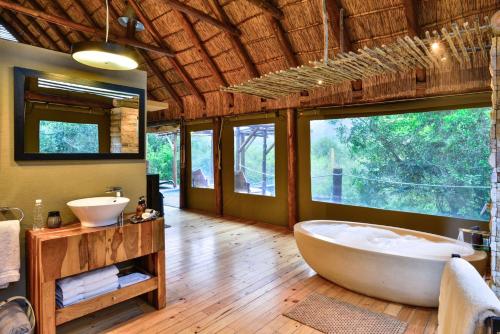 a bathroom with a large tub and two sinks at Shamwari Bayethe in Paterson
