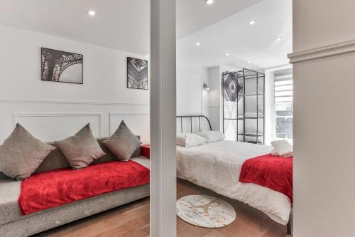 - une chambre avec 2 lits et une couverture rouge dans l'établissement 40-Flat Paris Eiffel, à Paris