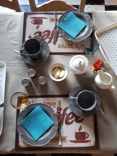 une table avec des serviettes et des assiettes bleues, dans l'établissement Escale de Brionsart, à Gesves