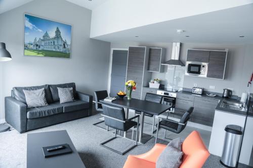 a kitchen and living room with a black table and chairs at Dream Apartments St Thomas Hall in Belfast