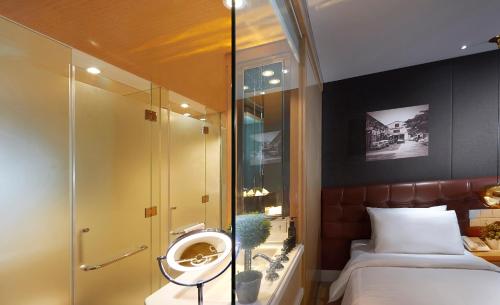 a bathroom with a mirror and a bed at Kingwood Boutique Hotel in Miri