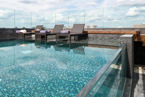 a swimming pool on the roof of a building at Akyra Manor Chiang Mai SHA Extra Plus in Chiang Mai