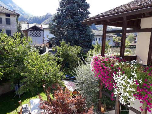 a garden with flowers and a gazebo at Garni Meinrad in Ora/Auer