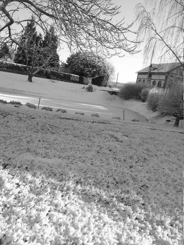 a snow covered yard with a house and a street at Le Cardonnet in Pont-Saint-Pierre