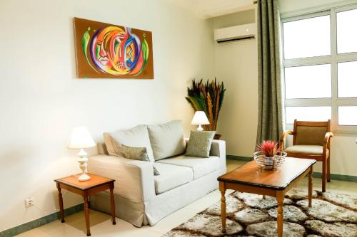 a living room with a white couch and a table at Tchero Appartement 2 in Douala