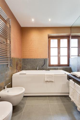 a bathroom with a tub and a toilet and a sink at Solo Experience Hotel in Florence