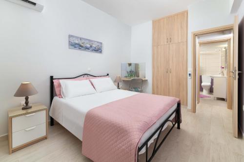 a bedroom with a large bed with a pink blanket at Lilla Cozy House in Rhodes Town