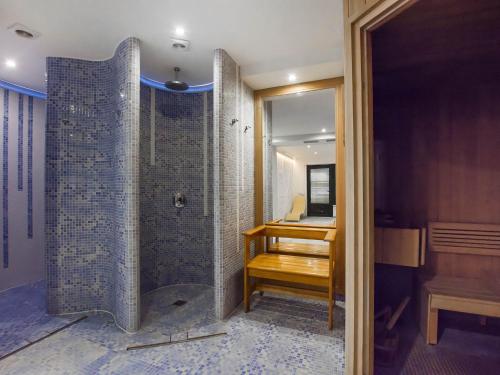 y baño con ducha, escritorio y espejo. en VacationClub - Rezydencja Park Apartament 30 en Mielno