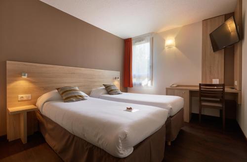 A bed or beds in a room at Logis Des Trois Massifs